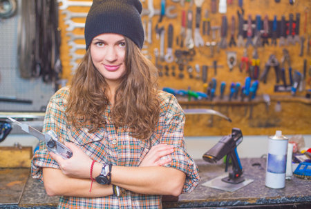 Pretty girl in the workshop with a toolの写真素材