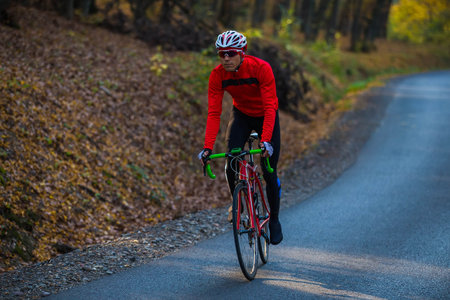 young man in bikers clothes riding a racing bicycleの写真素材