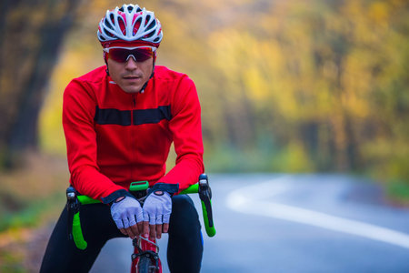 young man in bikers clothes riding a racing bicycleの写真素材