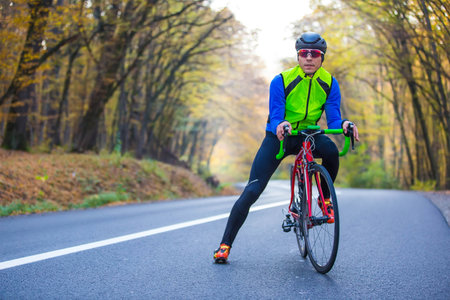 young man in bikers clothes riding a racing bicycleの写真素材