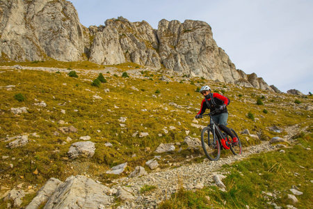 young boy cycling throuh rocky terrain with his trail bikeの写真素材