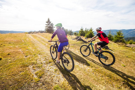 bikers riding by rural path at the top of the hill with beautiful viewの写真素材