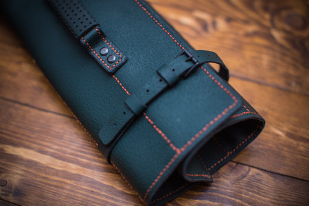 Green leather pouch with orange stitching and buckle.の写真素材