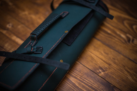 A stylish leather roll accessory displayed on a wooden background in close-up.