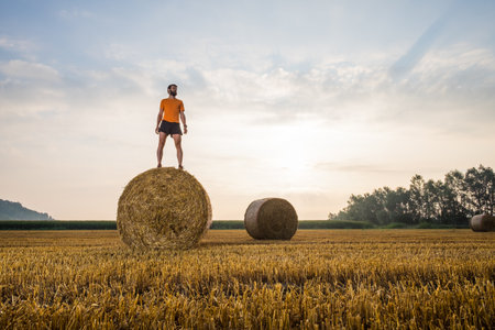 Man running in a wheat field in the countryの写真素材