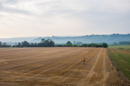 Man running in a wheat field in the countryの写真素材