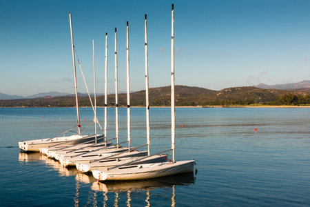 Sailboats anchored near beach on serene seaの写真素材