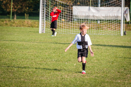 Young child boy (8-9) playing soccer during organized team league gameの写真素材