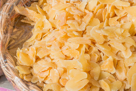 Candied and dried Crystallized Ginger slices in wicker bowlの写真素材