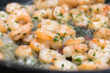 Closeup of freshly fried shrimp with fresh herbs on a frying panの写真素材