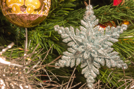 bright silver six point star decoration on green christmas treeの写真素材