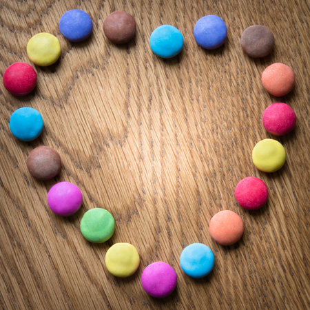 Colorful candy heart on wooden backgroundの写真素材