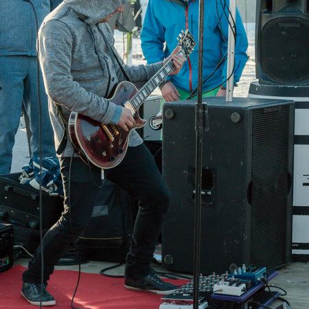 hoodie guitarist playing electrical guitar on a concertの写真素材