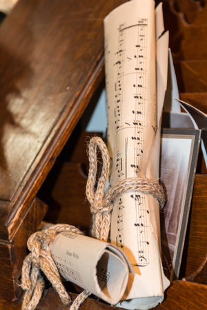 Rolled Music Sheet with aged photo over wooden drawer, composition paper closeupの写真素材