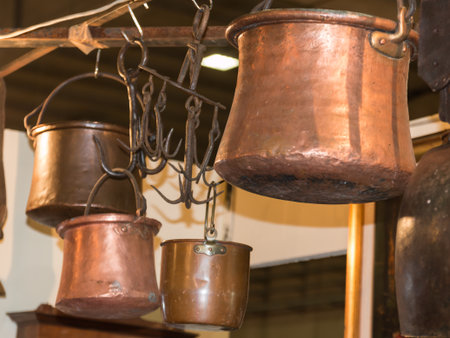 old copper pots hanged on iron hooks, cookwareの写真素材