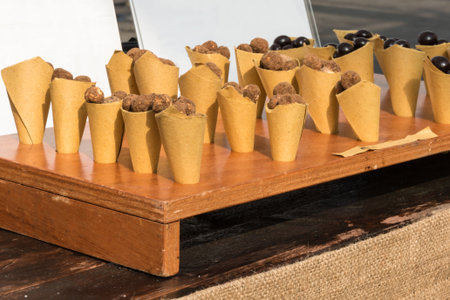 group of sugared almond in paper cones, chocolate on wooden boardの写真素材