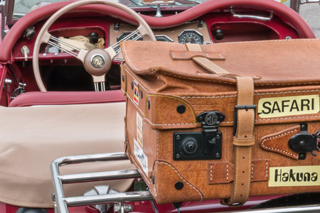 Brown Full-leather Suitcase on MG Retro Vintage Car Spare Wheel, Travel Conceptsの写真素材