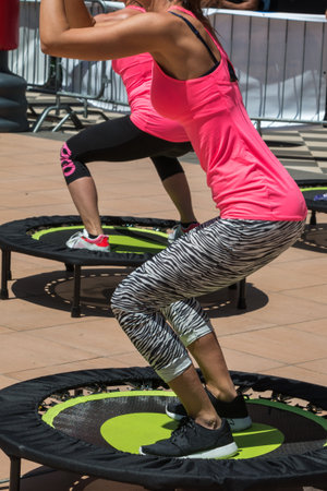 Pretty Girl with Pink Sportswear Having Exercise on Rebounderの写真素材