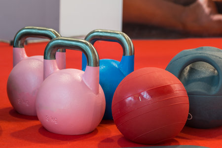 pink and blue rubber kettlebell and medicine ball on red carpetの写真素材