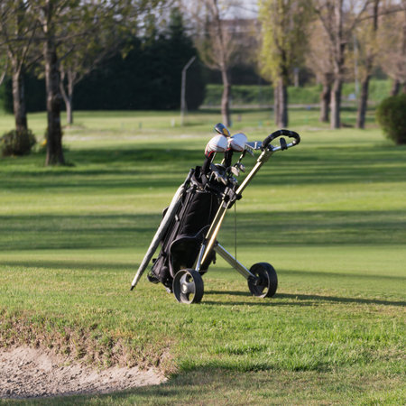 Black Golf Bag With Wheels in golf course in sunny dayの写真素材
