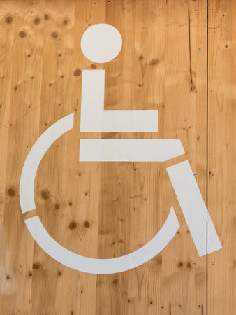 Handicap Wheelchair WC Sign: White Restroom Symbol on Wooden Backgroundの写真素材