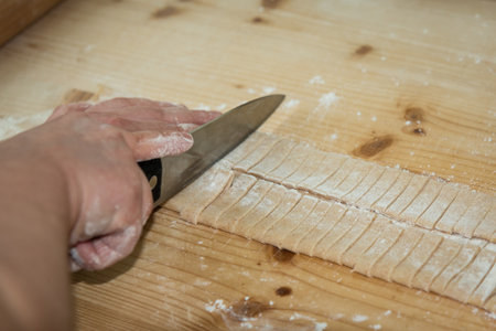 Preparation of Raw Homemade Italian Pasta on Wooden Cutting Boardの写真素材