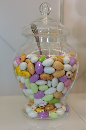 Colourful Sugared Almond inside Glass Jars on White Shelf