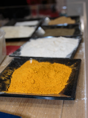 Fresh Orange Turmeric Powder inside Squared Dish and Other Spices in background