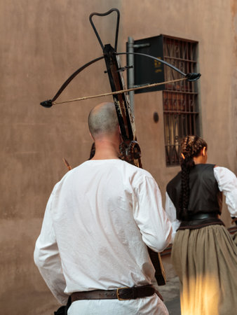 Man with White Shirt and Woodden Crossbow: Medieval Ancient Weapon during Paradeの写真素材