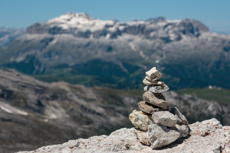 Stones Stacked One Onto Each Other and Mountain Ridge in Italian Dolomites Alps in Summer Time in Backgroundの写真素材