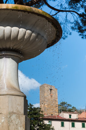 White Fountain with Water flowing Out and Castle in Background, Vicopisano, Pisa - Italyの写真素材