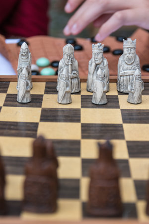 Closeup of Artistic Chess Pieces on Wooden Board: Strategy and Leadership Concept Gameの写真素材