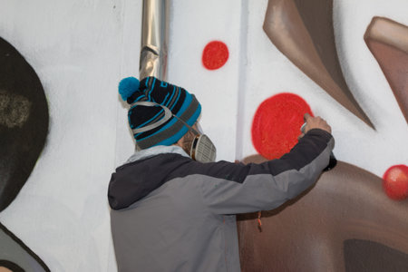 Male Street Artist: Spraying on Public Urban City Wallの写真素材