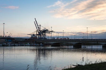 Container Terminal, Shipyard and Cranes at Sunset and Their Reflectionの写真素材