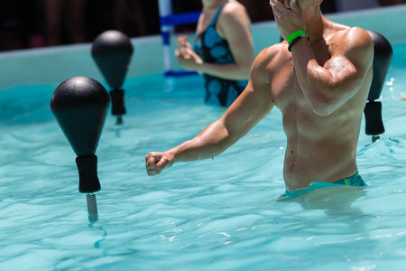 People Doing Water Aerobics with Boxing Speed Ball in an Outdoor Swimming Pool.の写真素材