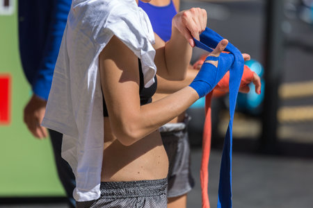 Girl Wrapping Her Hands with Blue Hands Wraps: Fitness and Boxing Workoutの写真素材