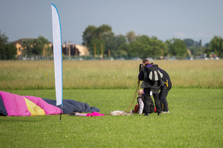 Instructors Help Old Parachutist Man on the Ground after Launch.の写真素材
