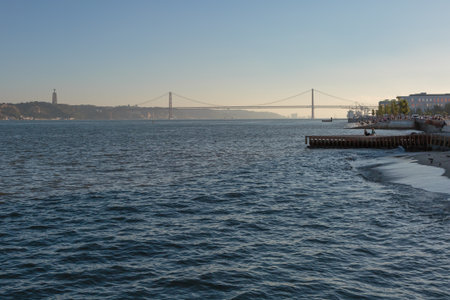25th April Bridge in Lisbon and a Couple on Wodden Pier.