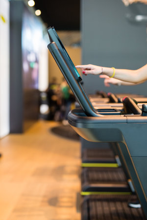 Detail of Fingers Touching a Touchscreen of Modern Running Machine in a Fitness Centerの写真素材