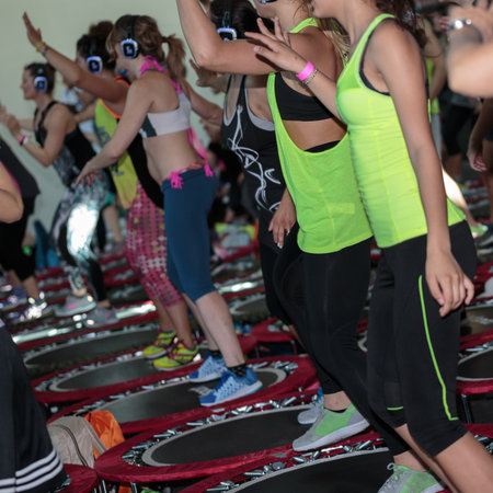 Mini Rebounder Workout: Girls with Headphones doing Fitness Exercise at Gym.のeditorial素材