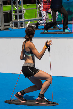 Girl having Fitness Workout Outdoor with Base Equipment with Elastic Bands.のeditorial素材
