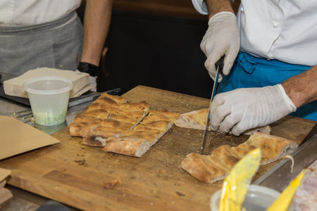 Chef Cutting Pieces of Focaccia to Prepare Appetizers.
