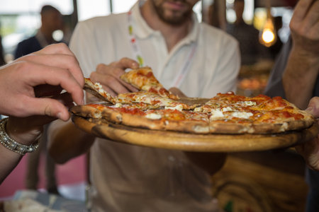 Taking Slices of Pizza on a Wooden Chopping Board.