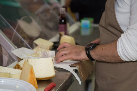 Maid who Slices Cheese in a Food Store.の写真素材
