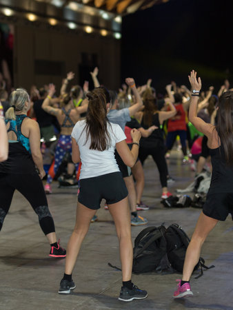 Fitness Workout in Gym: People doing Exercises in Class with Music and Teacher on Stage.の写真素材