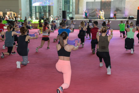 Girls Exercising with Gym double handle Dumbbell  in Fitness Class at Gym with Music and Teacher on...