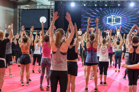 Fitness Workout in Gym: People doing Exercises in Class with Music and Teacher on Stage.の写真素材