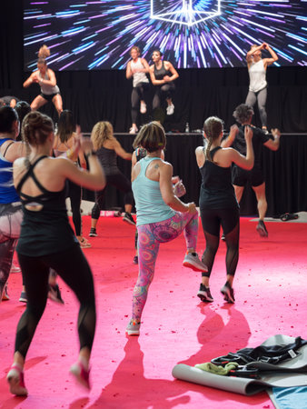 Fitness Workout in Gym: People doing Exercises in Class with Music and Teacher on Stage.のeditorial素材