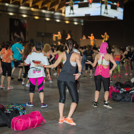 Fitness Workout in Gym: People doing Exercises in Class with Music and Teacher on Stage.のeditorial素材