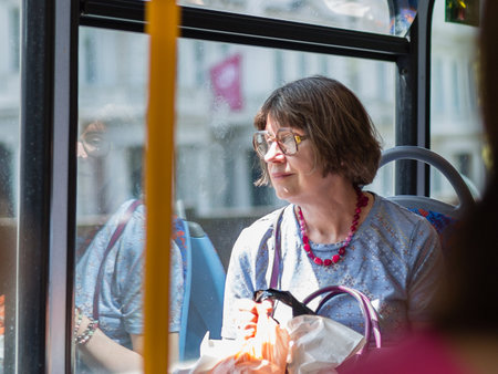 Street Photography: Elderly Lady with Glasses Sitting on City Bus in London.の写真素材